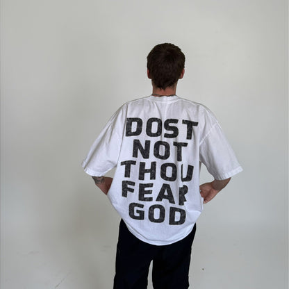 Person wearing a white t-shirt with 'DOST NOT THOU FEAR GOD' text on the back against a plain background